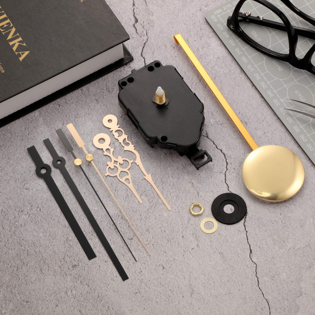 Quartz pendulum clock movement kit with hands and pendulum, laid out on a textured surface next to a book and glasses.