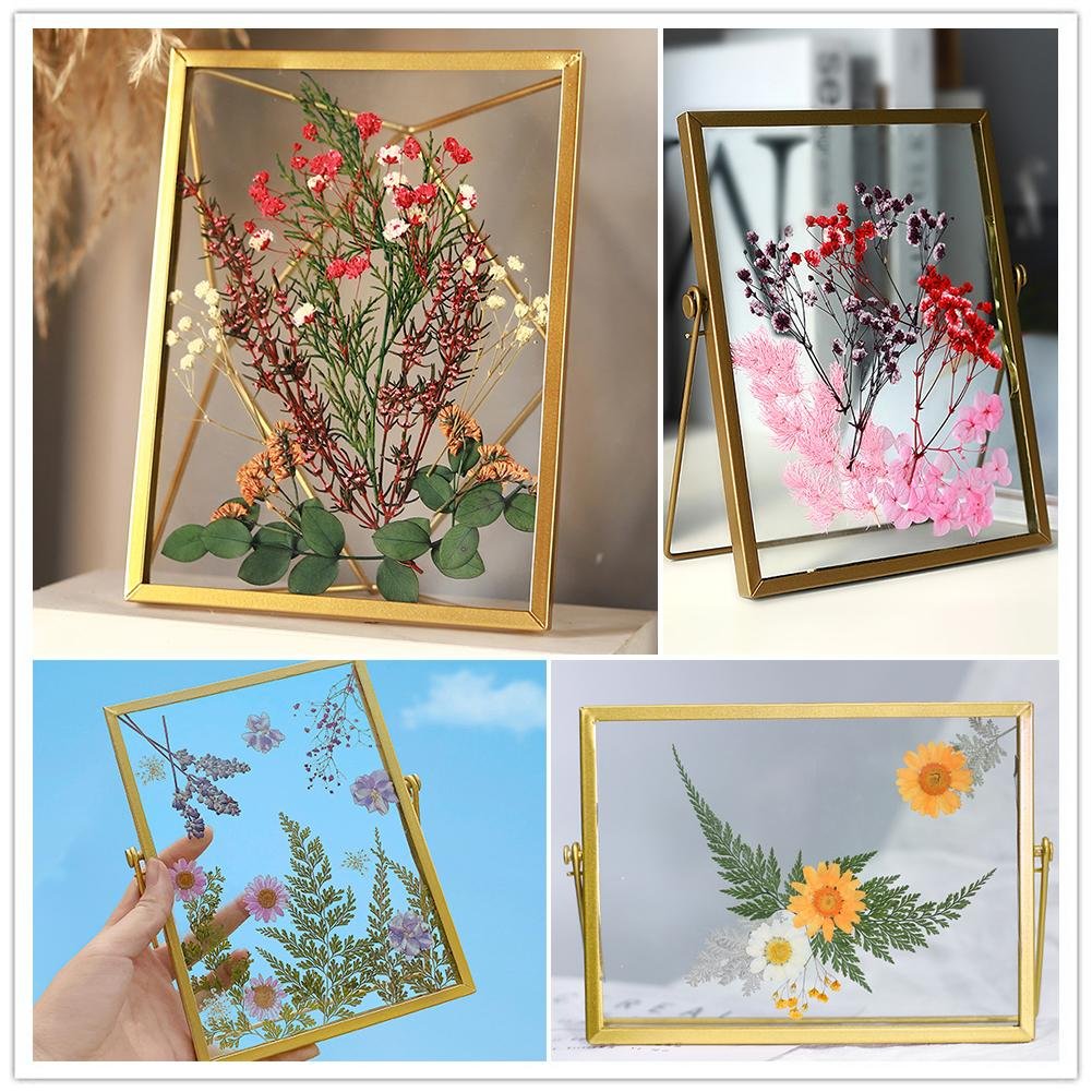 Four glass frames with dried pressed flowers and leaves in various arrangements.