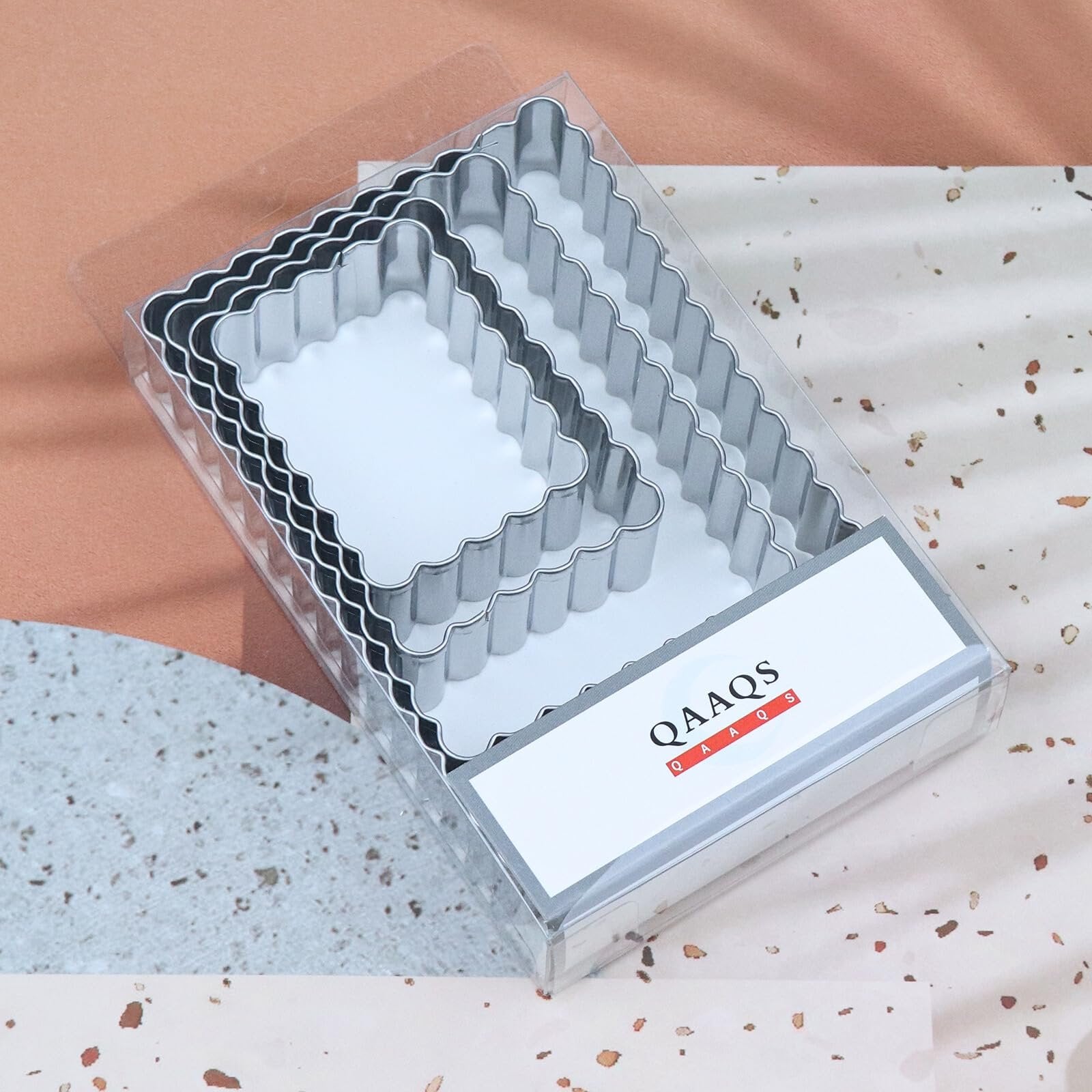 Set of rectangular cookie cutters with scalloped edges in clear packaging, angled view.