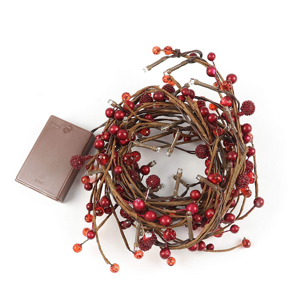 Red berry and LED light garland coiled with a brown battery pack on a white background