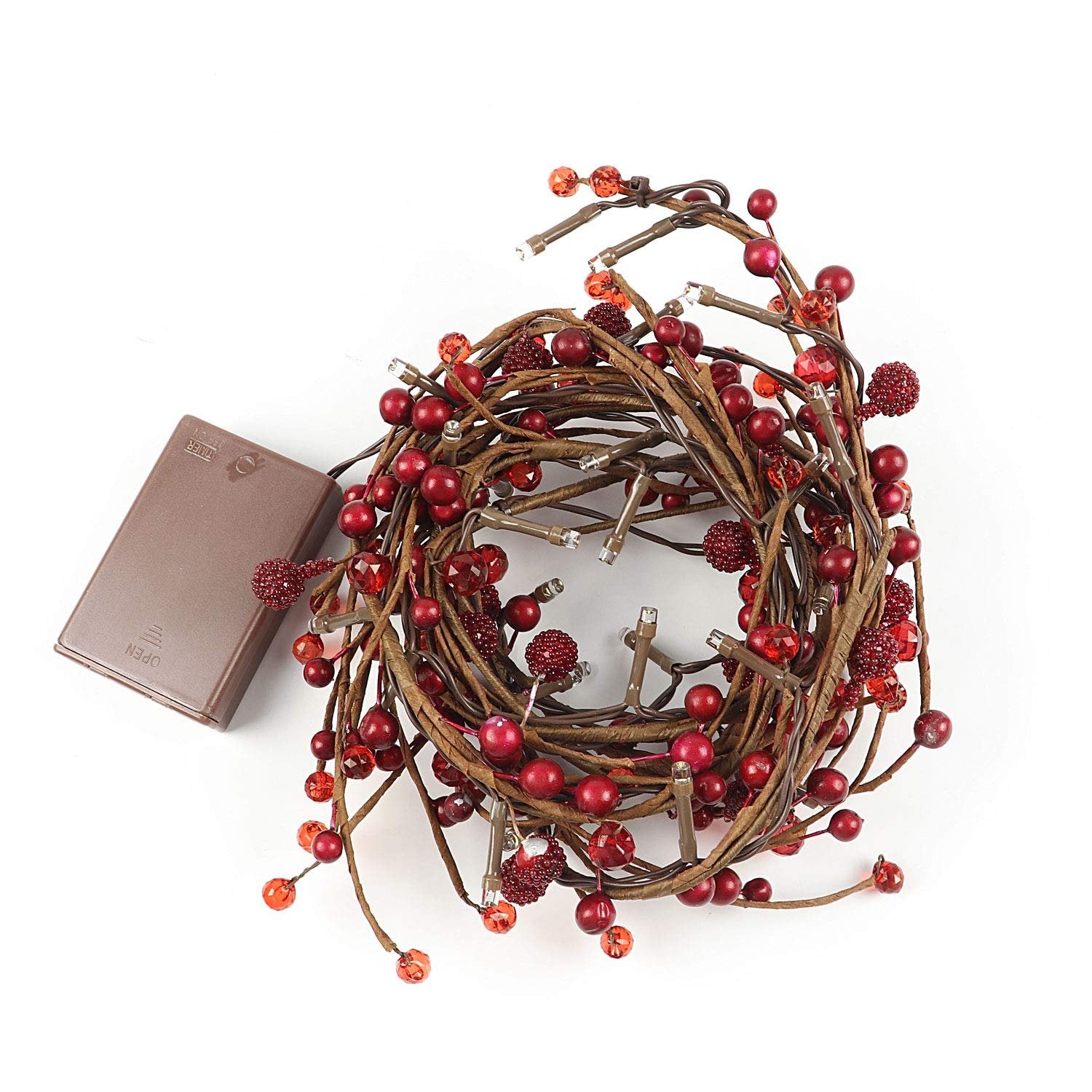 Red berry and LED light garland coiled with a brown battery pack on a white background
