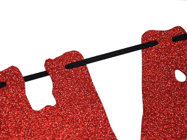 Close-up of a red glitter paper bat banner with black string, showing the texture and glitter detail.