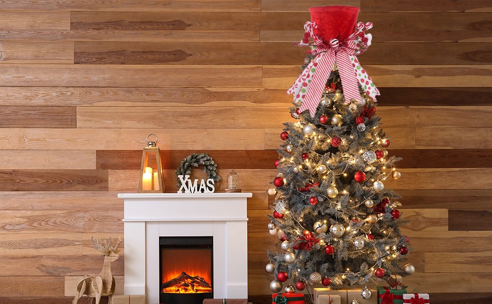 Christmas tree topper shaped like a red velvet hat with candy cane accents and a large striped bow, placed on a decorated Christmas tree.