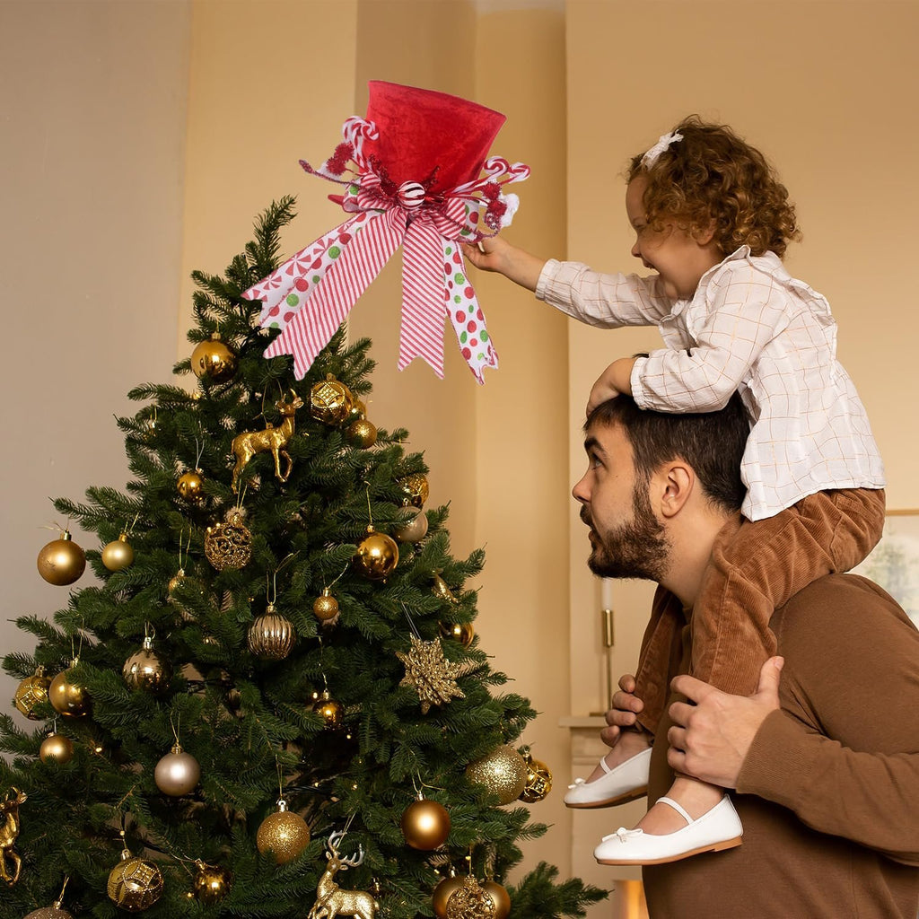 Father and daughter placing a red velvet candy cane Christmas tree topper with ribbons on a decorated tree