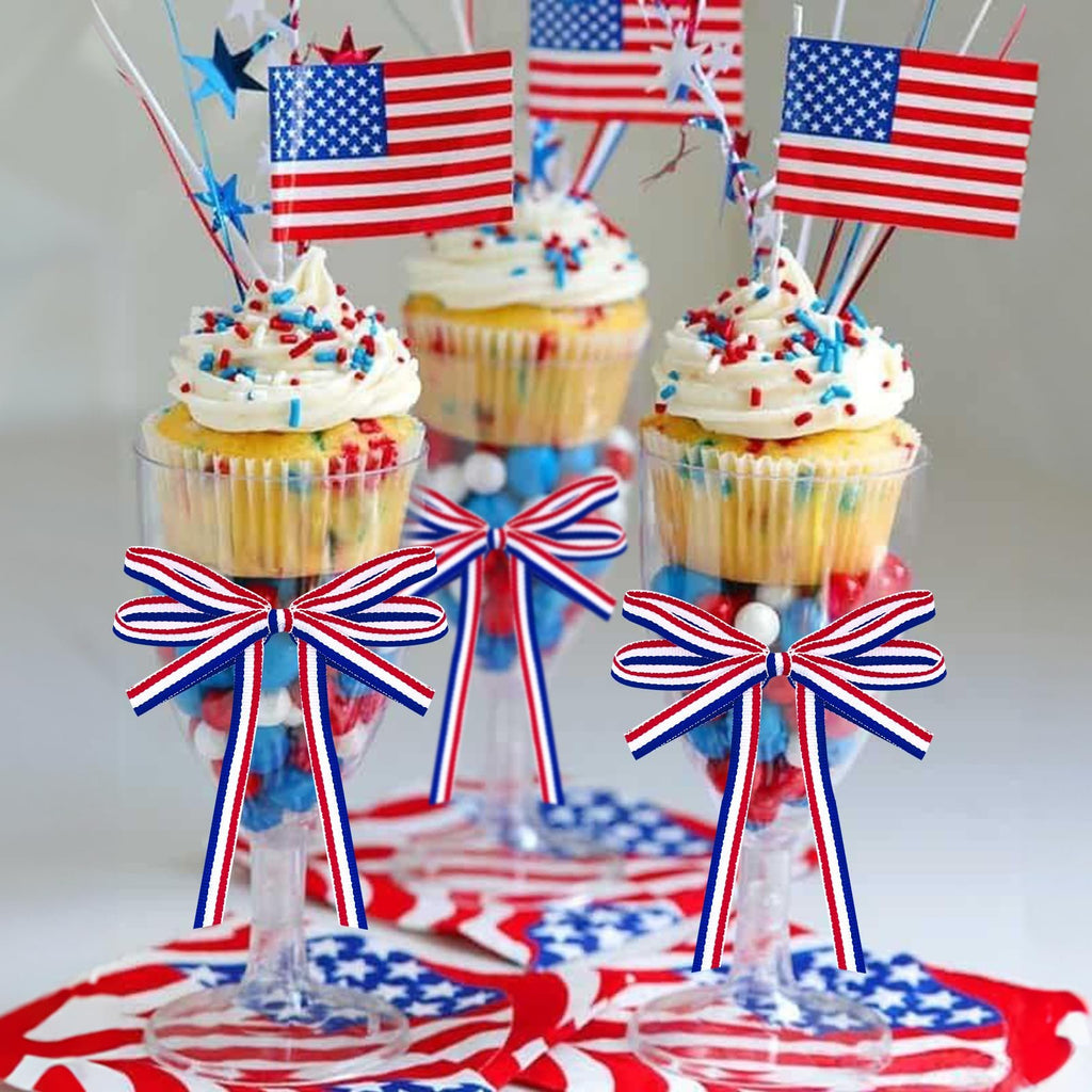 Patriotic cupcakes decorated with American flags and red, white, and blue sprinkles in clear glasses filled with candy.