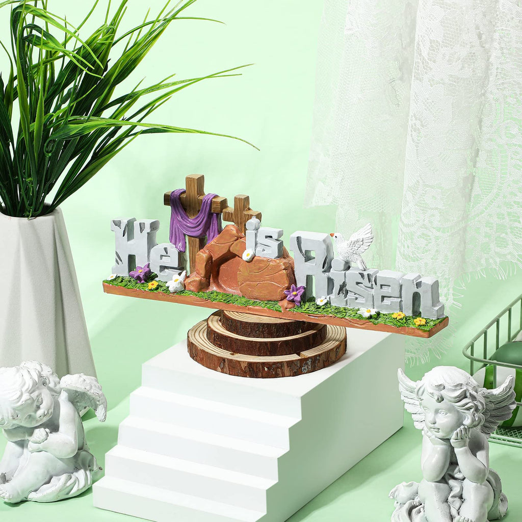 Easter figurine with 'He is Risen' text, crosses, tomb, dove, and bunny on a wooden base.