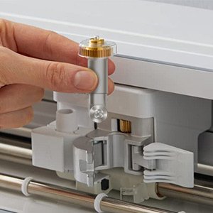 Hand inserting rotary blade and drive housing into cutting machine mechanism