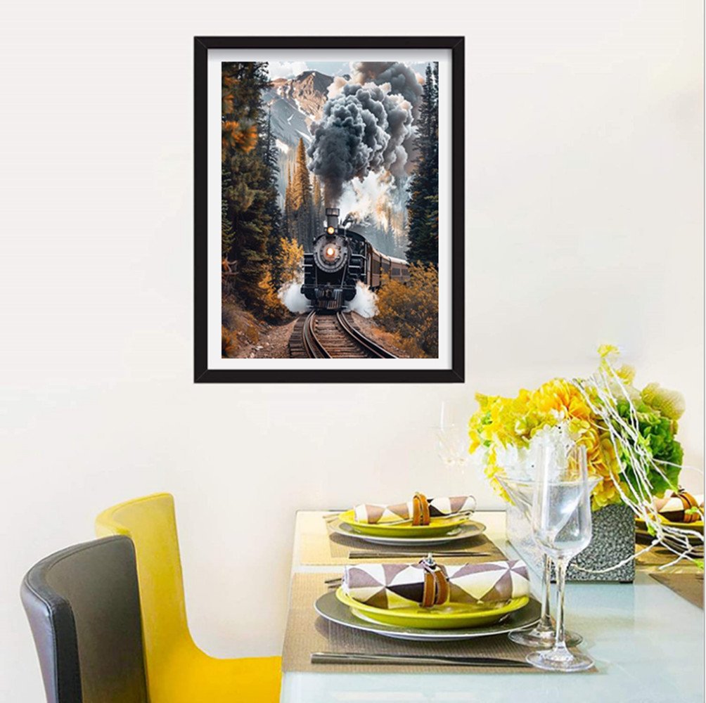 Framed diamond painting of a steam train emerging from a forest with mountains in the background.