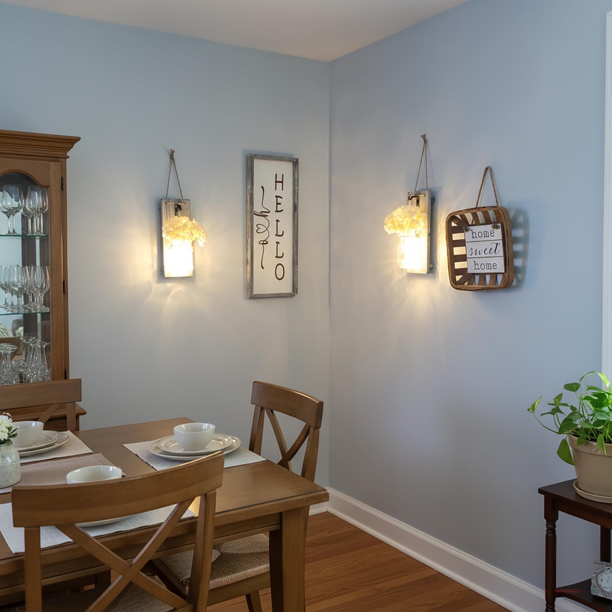 Rustic farmhouse wall sconces with mason jars and LED lights flanking a dining table.
