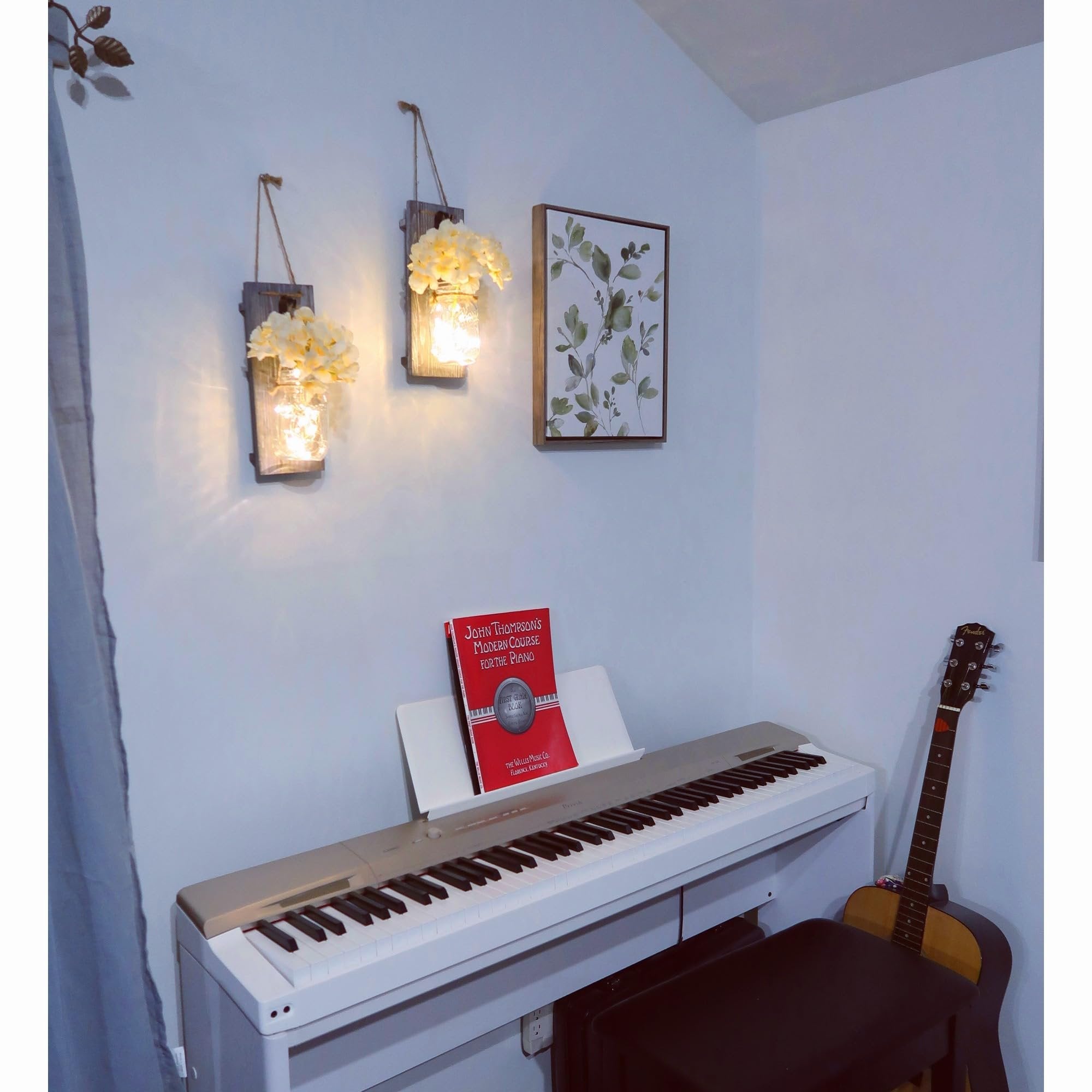 Rustic wood wall sconces with mason jars and faux flowers flanking a piano with a music book and guitar