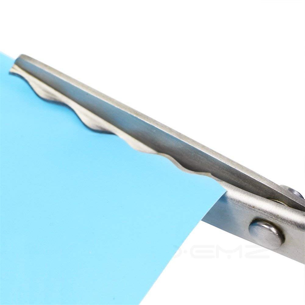 Close-up of scalloped pinking shears cutting light blue paper, showing the serrated blade and metal pivot.