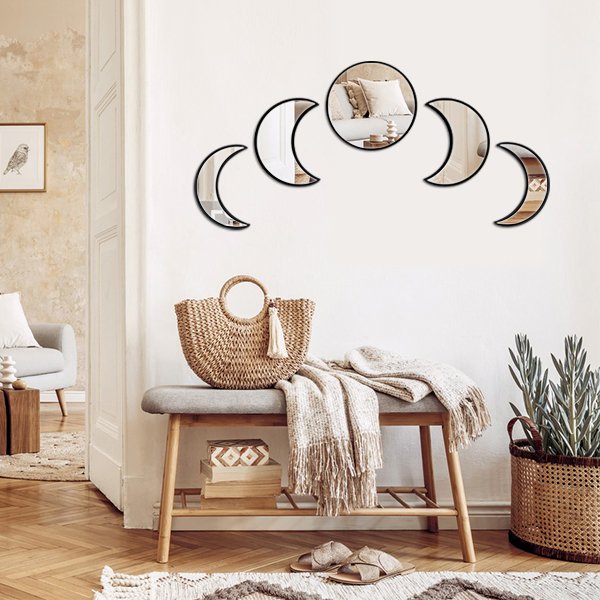 Scandinavian moon phase wall mirror set with wooden frame, displayed on a white wall above a bench with a woven bag and blanket.