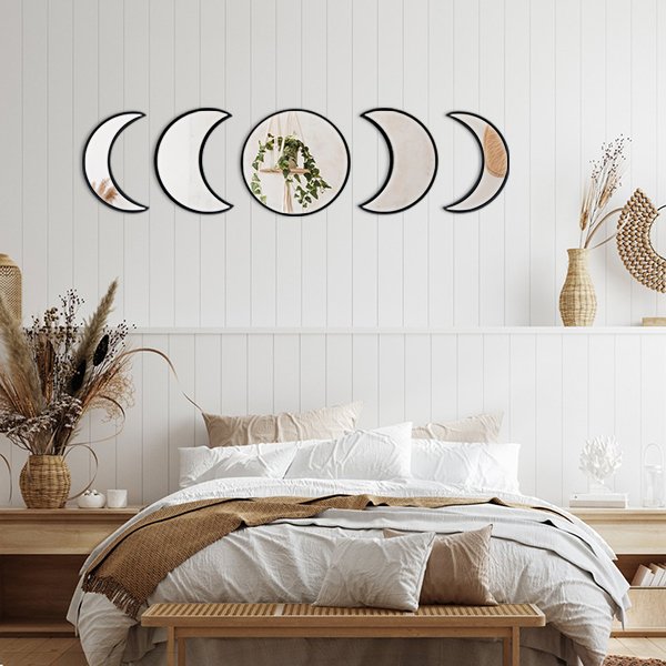 Scandinavian moon phase wall mirror set with wooden frames, displayed above a bed in a bohemian-style bedroom.