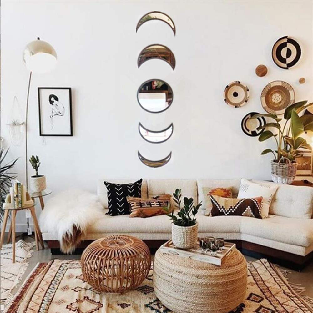 Scandinavian moon phase wall mirror set arranged on a white wall above a sectional sofa in a bohemian living room.
