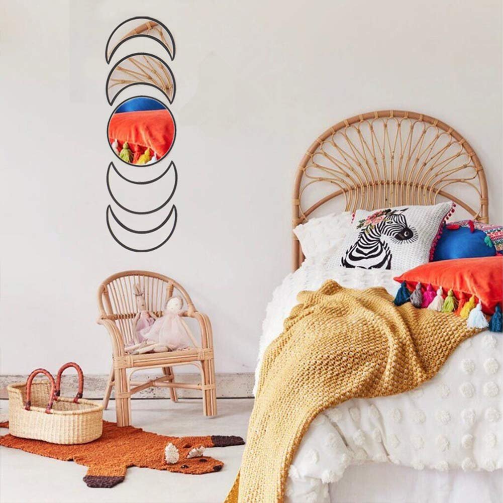 Acrylic moon phase wall mirror set with wooden frame, displayed in a bohemian-style bedroom with a rattan headboard and colorful pillows.