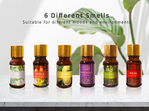 Six small amber glass bottles of aromatherapy oils with gold caps, labeled Jasmine, Apple, Lemon, Lavender, Vanilla, and Rose.