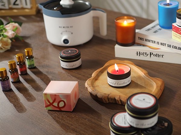 Scented candle making kit components including fragrance oils, wax melter pot, and various candles on a wooden surface.