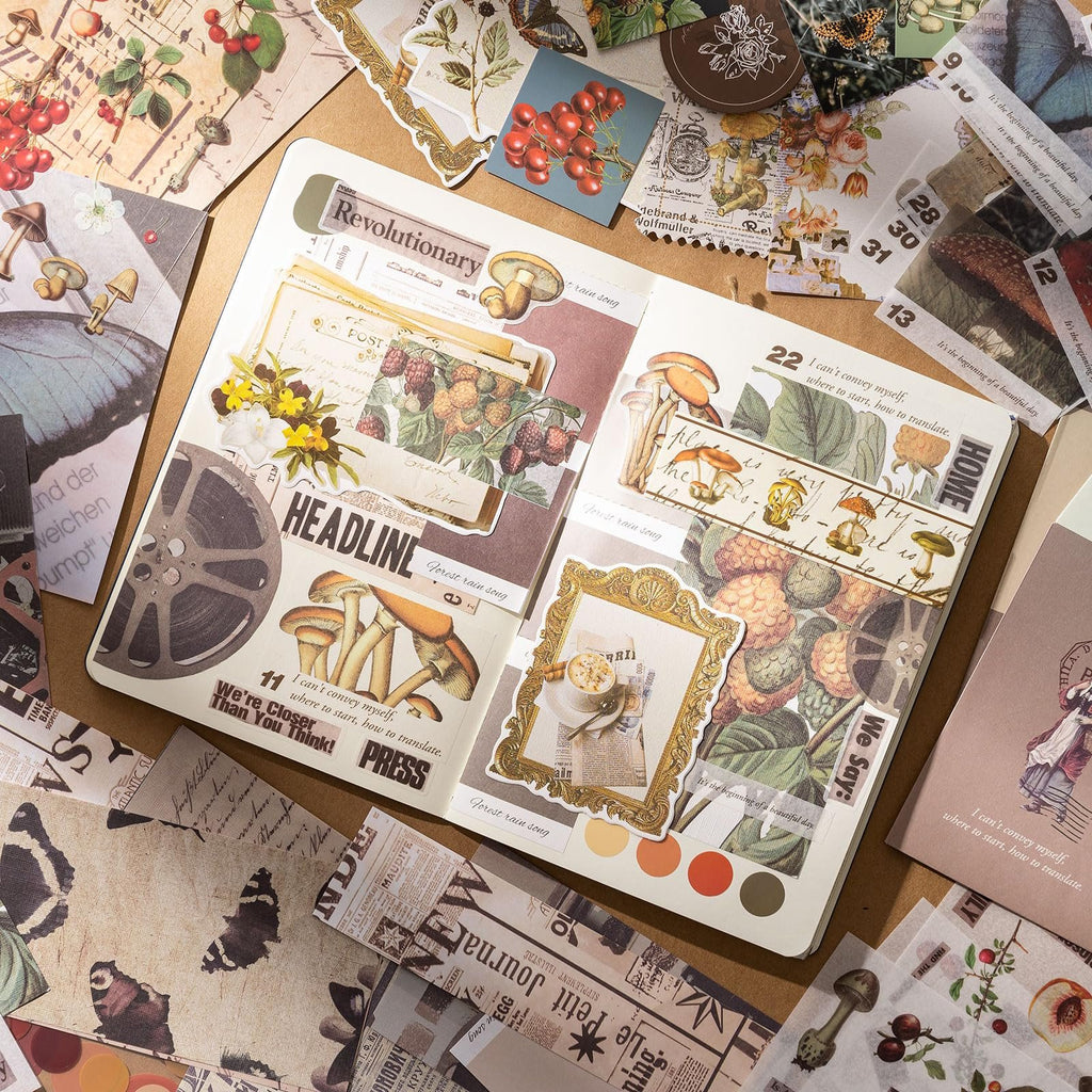 Scrapbook kit contents including stickers, washi tape, and paper with vintage botanical and butterfly designs, arranged in a journal.