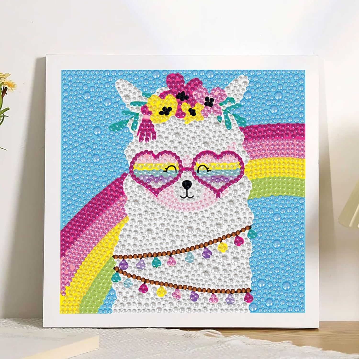 Diamond painting kit featuring a white llama wearing heart-shaped glasses and a flower crown, with a rainbow in the background.