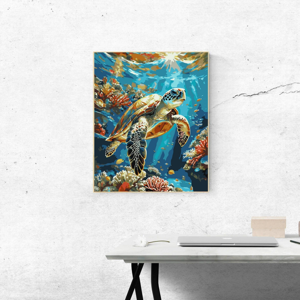 Framed paint by numbers artwork of a sea turtle swimming among coral reefs and fish, with sunlight filtering through the water.