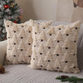 Two beige plush Christmas tree pillow covers with dark brown accents on a sofa, with a decorated Christmas tree in the background.