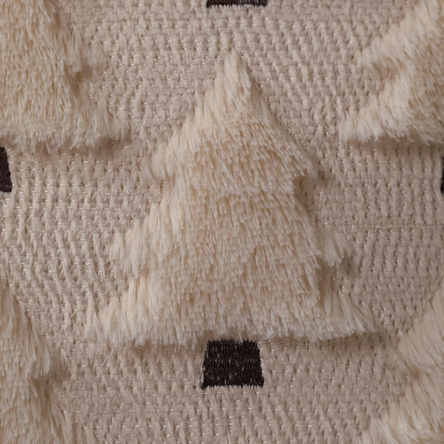 Close-up of a beige textured fabric with fluffy cream-colored Christmas trees and dark brown bases.