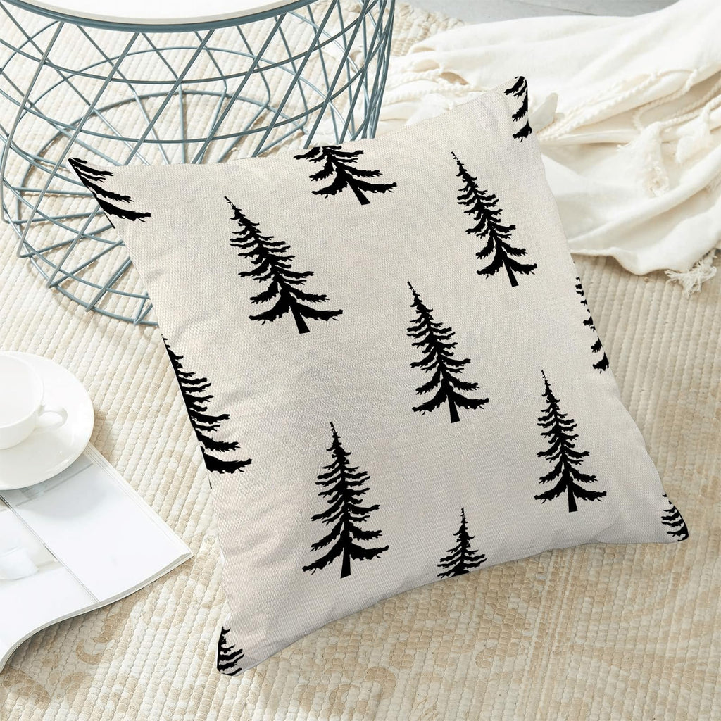 Cream and black Christmas tree pattern pillow cover on a rug with a white cup and magazine.