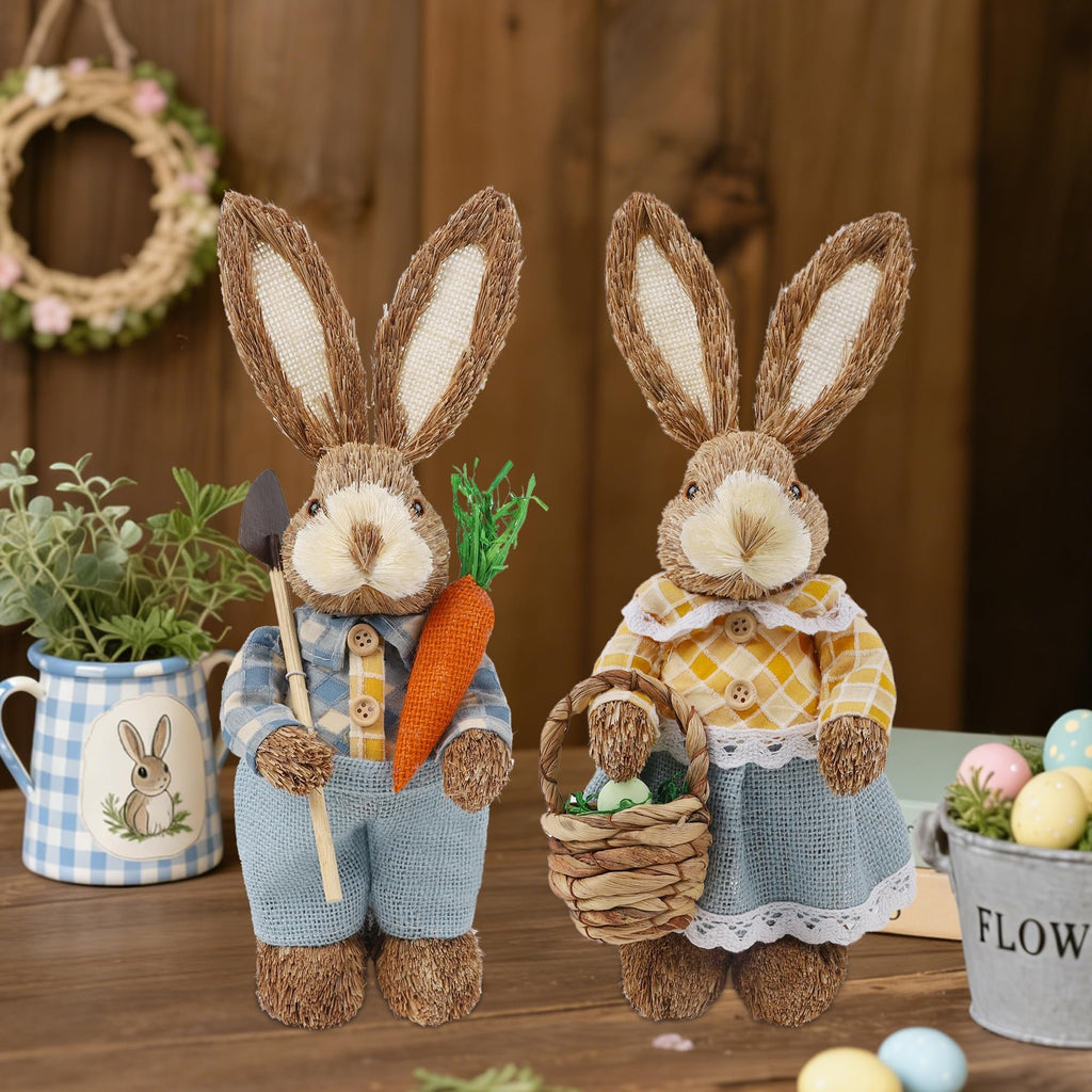 Two rustic Easter bunny figurines on a wooden surface, one holding a carrot and shovel, the other a basket with an egg.