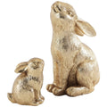 Two gold resin bunny figurines, one larger looking up and one smaller, on a white background.