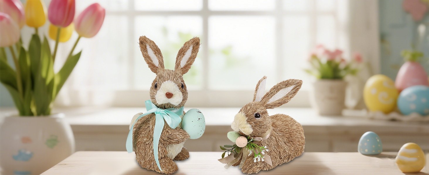 Two sisal bunny figurines with Easter eggs and ribbons on a wooden surface, with tulips and decorative eggs in the background.