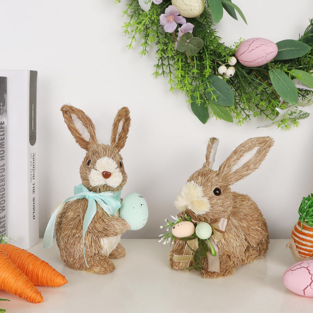Two sisal bunny figurines with Easter eggs and ribbons, displayed with books and carrots.