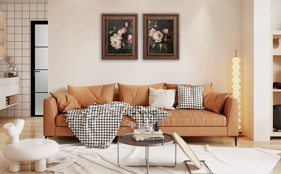 Two framed floral canvas prints hanging above a tan sofa in a living room setting.