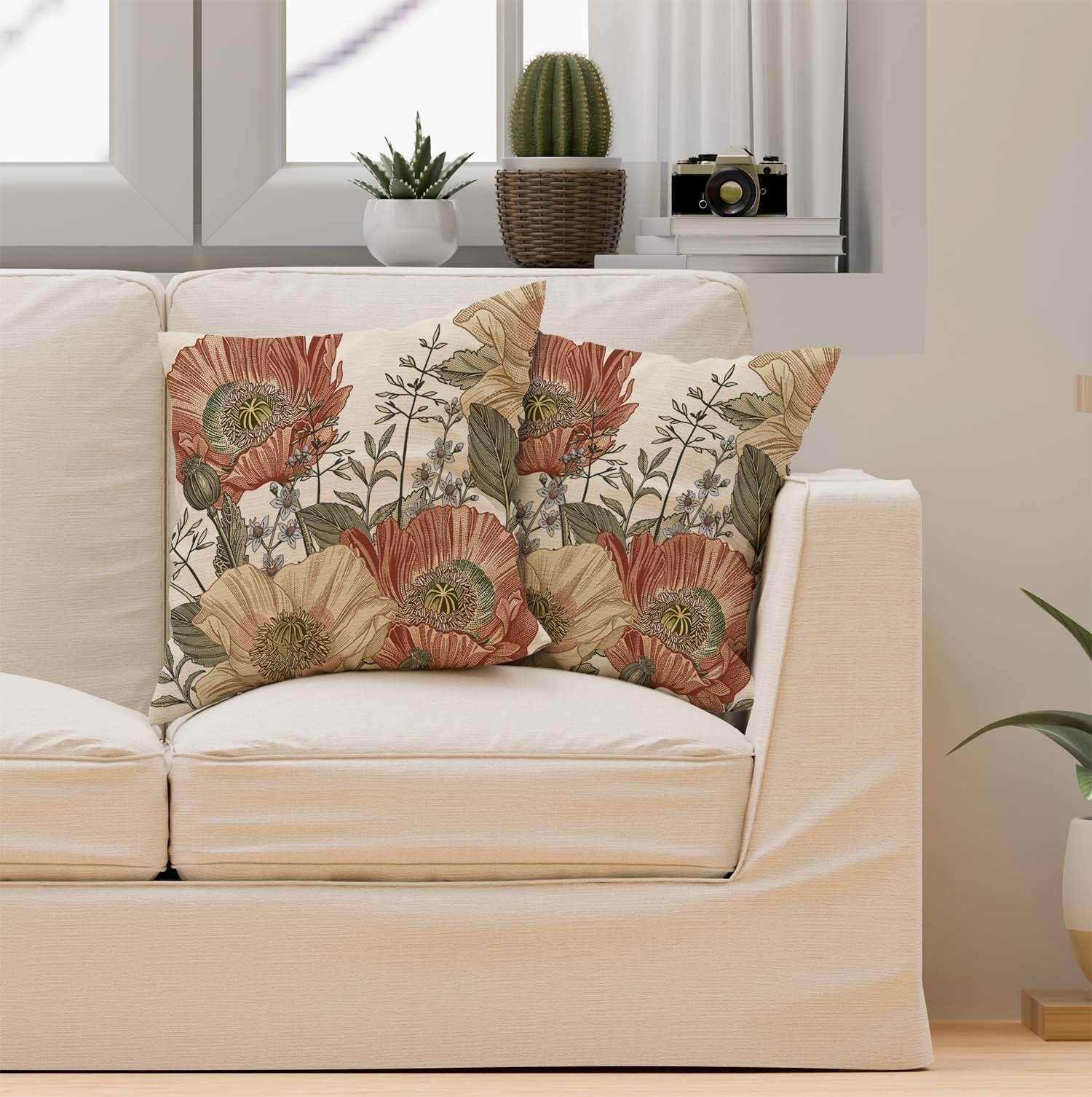 Two vintage floral pillow covers with brown, rust, and botanical patterns on a cream sofa.