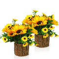 Two potted artificial silk sunflowers with green leaves in rustic bark-textured pots, displayed against a white background.