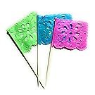 Three mini papel picado tissue paper flag picks in green, blue, and pink with flower designs on wooden sticks.
