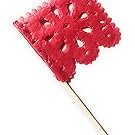 Red papel picado flag pick with intricate flower design on a white background