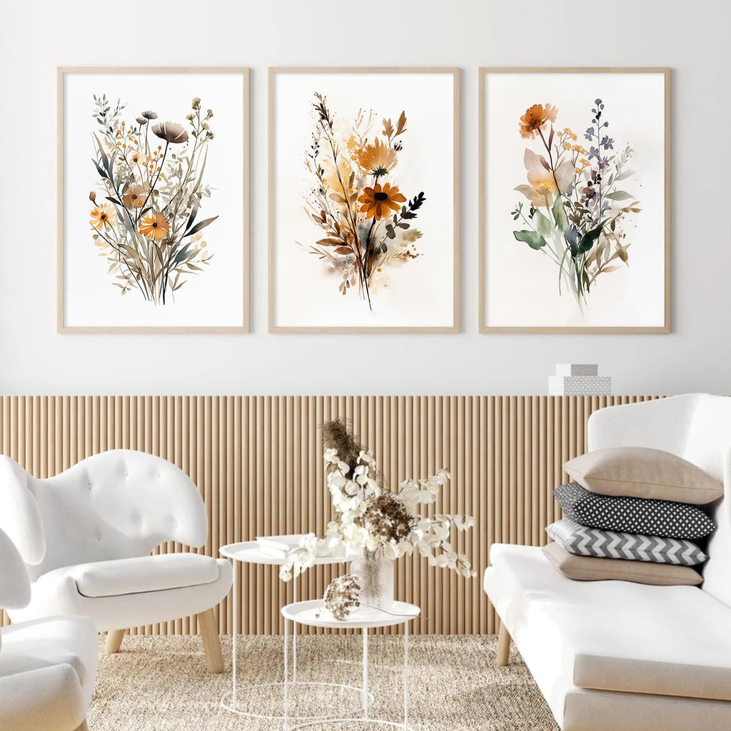 Three framed botanical wall art prints with wildflowers in watercolor style, displayed above a slatted wood panel wall.