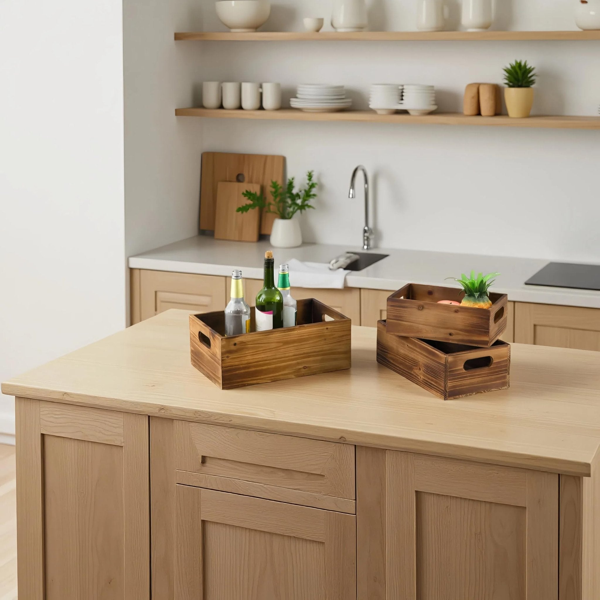 Three distressed fir wood crates with handles displayed on a wooden kitchen island, one filled with bottles and another with a plant.