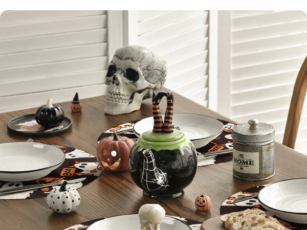 Halloween placemats with spooky ghost and pumpkin designs on a dining table with decorative items