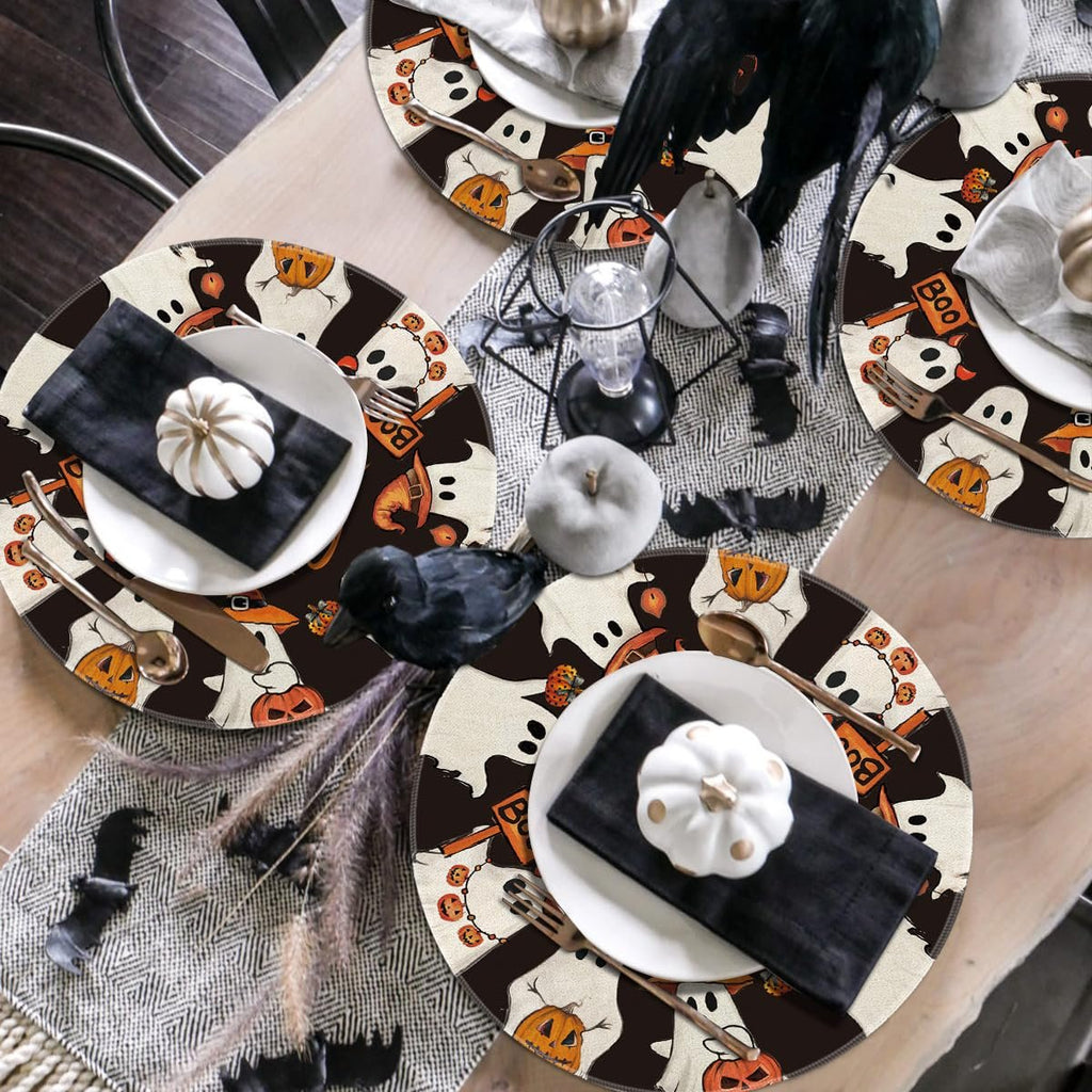 Four round Halloween placemats with ghost and pumpkin designs arranged on a table setting.