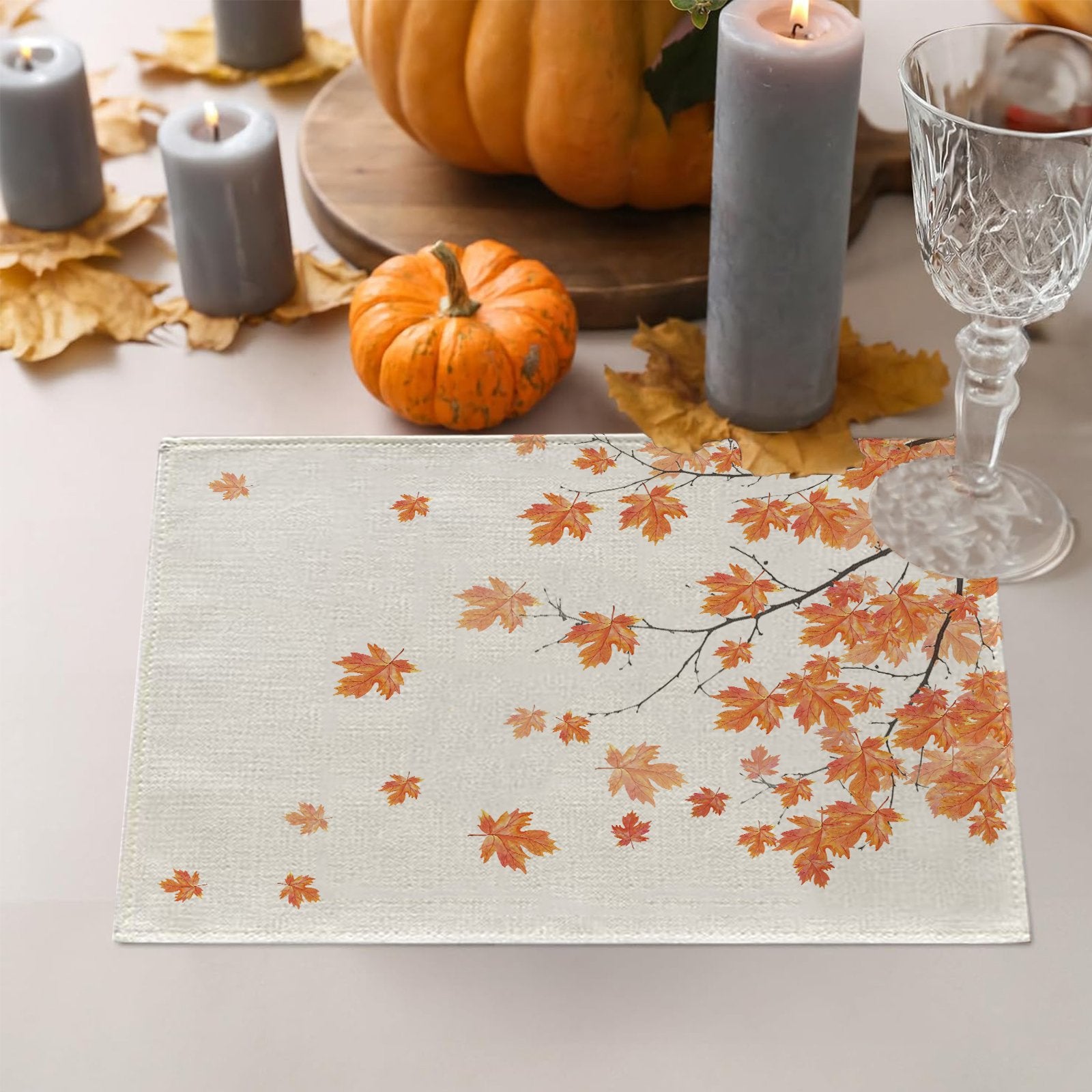 Fall placemat with autumn maple leaves design on a table with pumpkins and candles