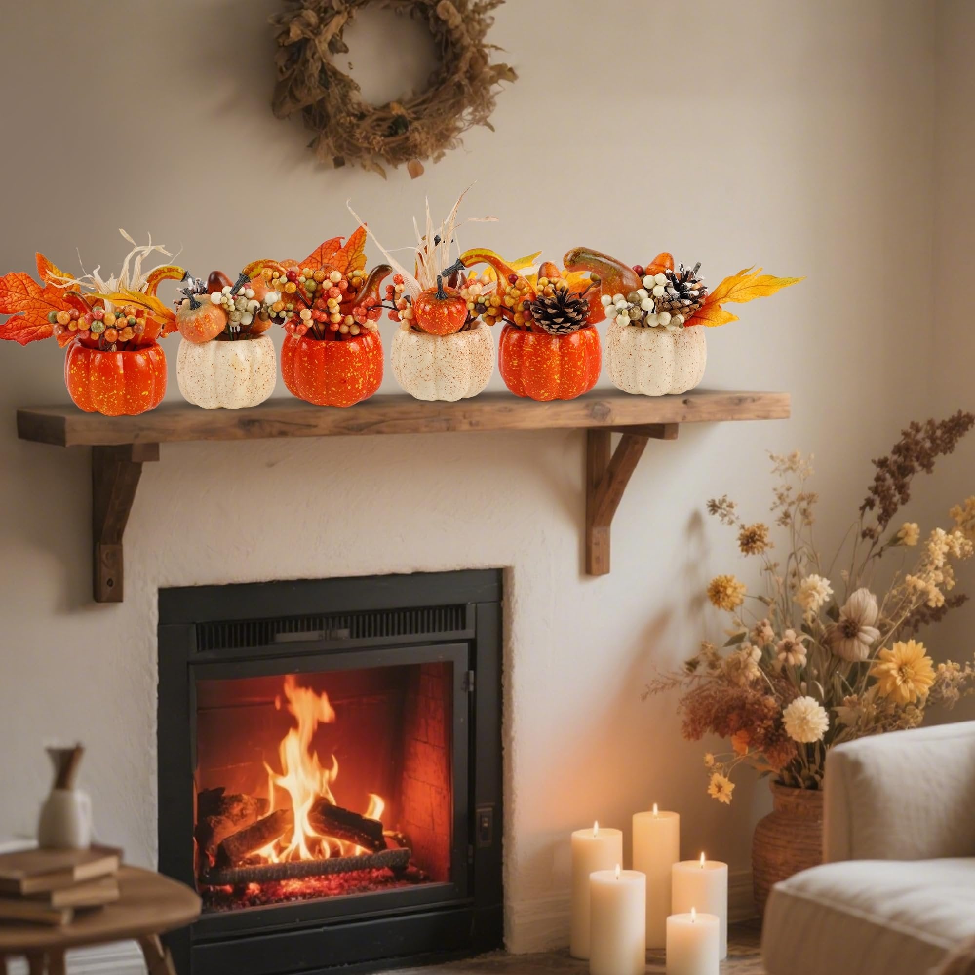 Set of six artificial pumpkins with fall foliage and berries arranged on a wooden shelf above a fireplace.