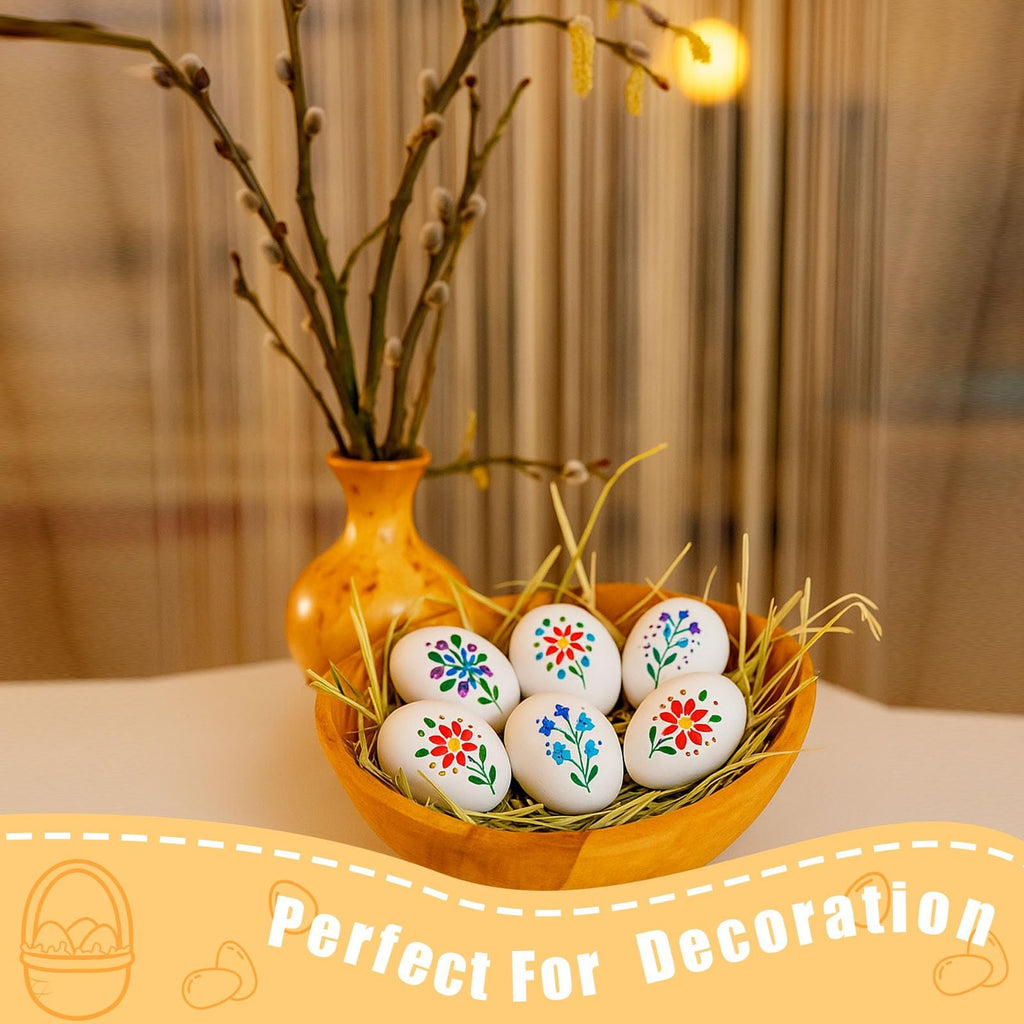 White wooden eggs with floral designs in a wooden bowl with pussy willow branches