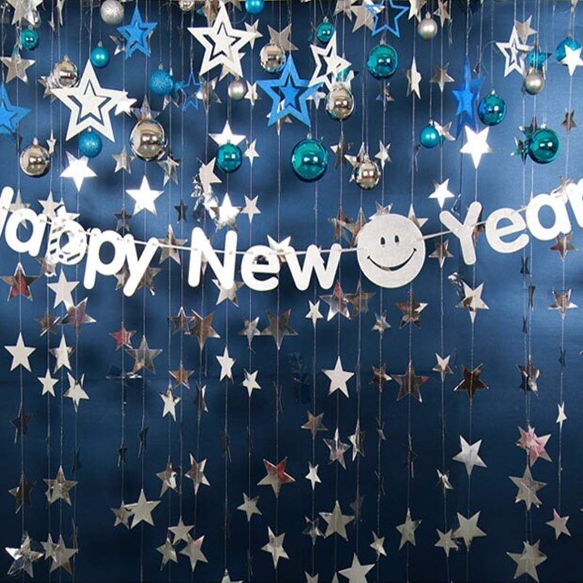 Silver and blue star garlands with a 'Happy New Year' banner and smiley face, hanging against a dark blue backdrop.