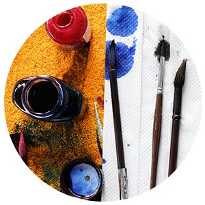 Art supplies including ink bottles, paintbrushes, and paint splatters on paper towels