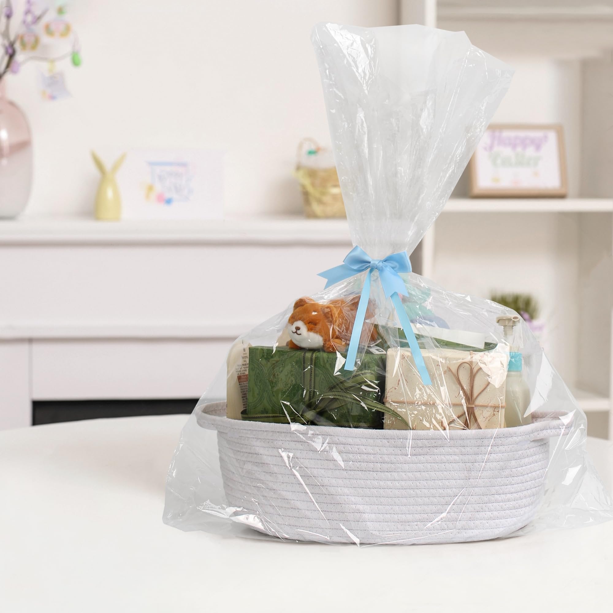 Woven cotton rope basket filled with gift items and wrapped in clear plastic with a blue bow.