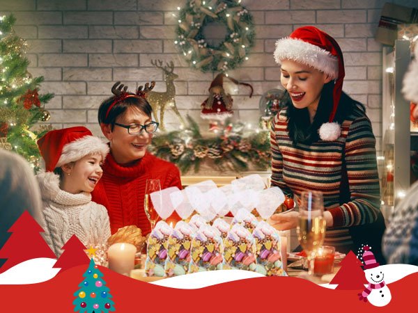 Family celebrating Christmas dinner with snowflake patterned treat bags filled with candy on the table