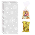 Stack of snowflake-patterned cellophane treat bags next to a filled bag and gold twist ties