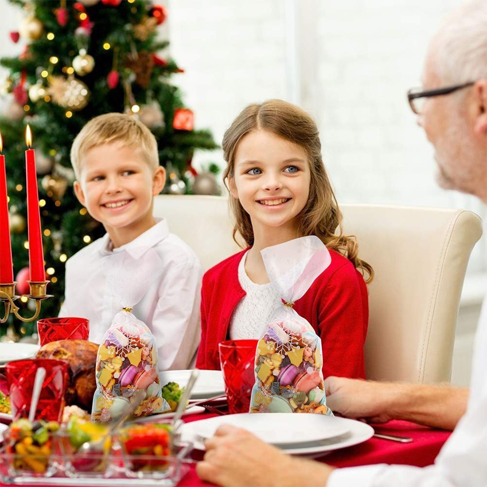 Children and adult at a holiday table with two bags of candy and cookies in clear cellophane bags.