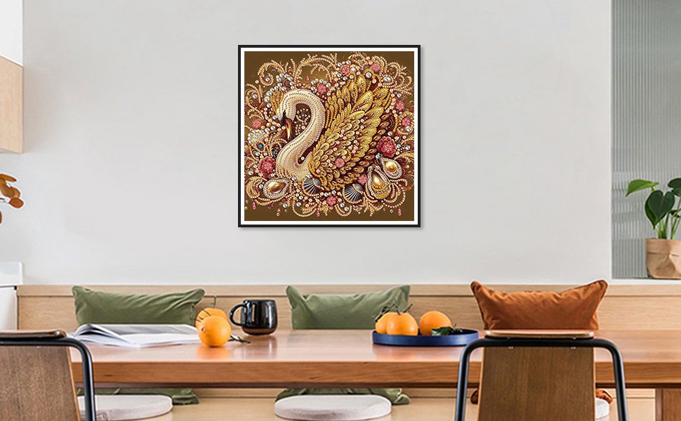 Diamond painting kit with a golden swan design, adorned with rhinestones and pearls, framed on a wall above a dining table.